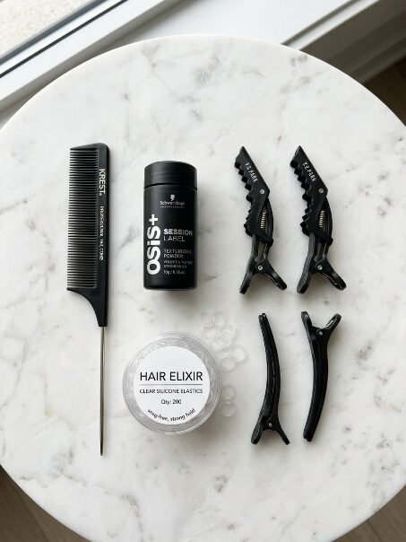 Krest rattail comb, OSiS+ powder, Y.S. Park clips, and a container of clear hair elastics.