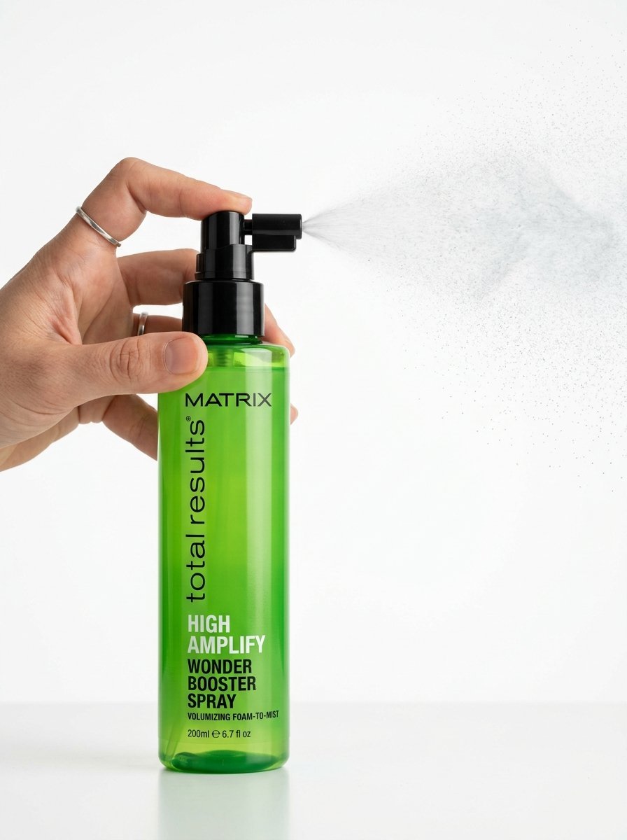 Close up of a hand holding a bottle of Matrix High Amplify hair product as it sprays a fine mist.