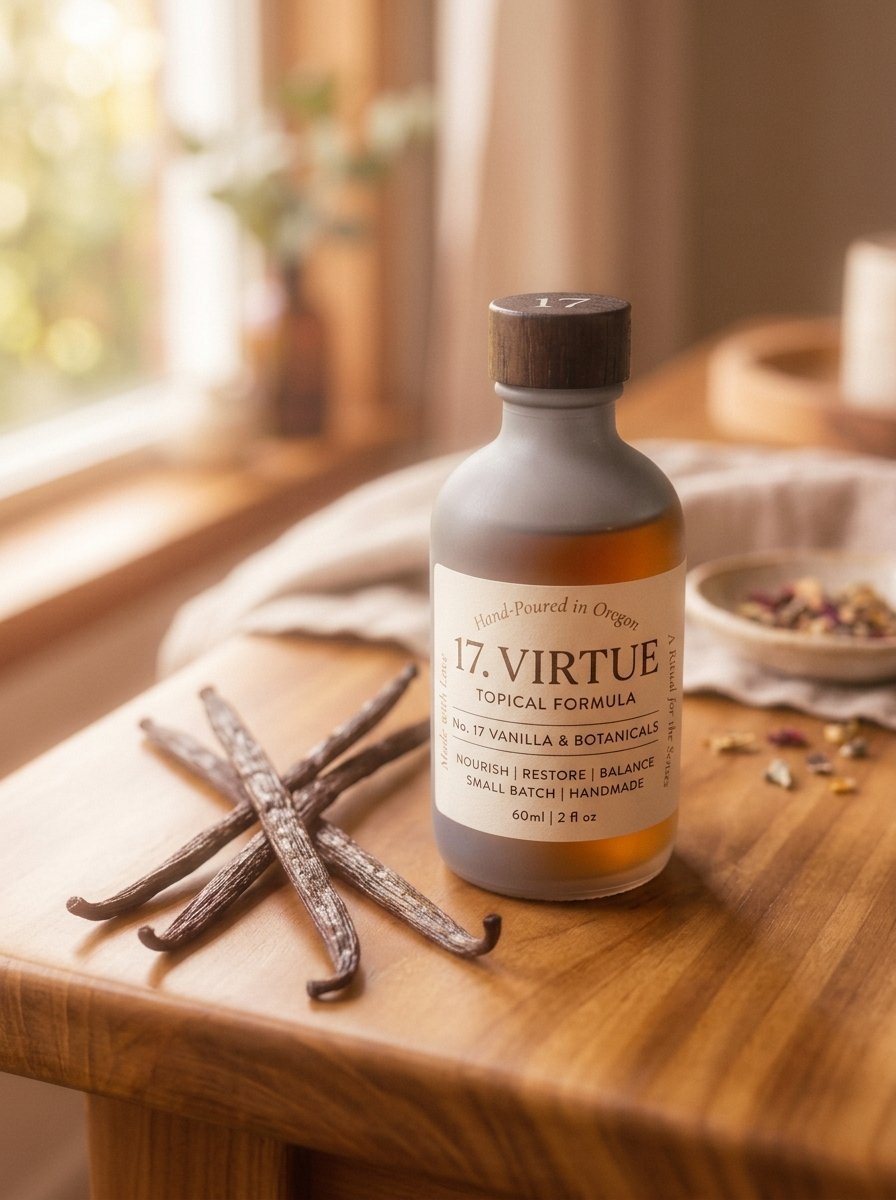 A frosted glass bottle of 17 Virtue vanilla and botanicals oil resting on a wooden table beside vanilla bean pods.
